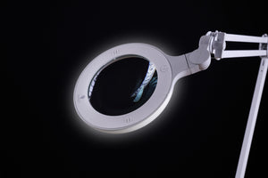 Omega 5 magnifying lamp against a black background 