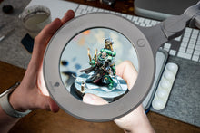 Load image into Gallery viewer, Omega 5 magnifying lamp being used to view a green and gold warrior miniature.
