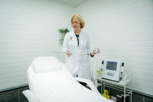 Load image into Gallery viewer, Image of a professional woman adjusting magnifying lamp in a clinical white room
