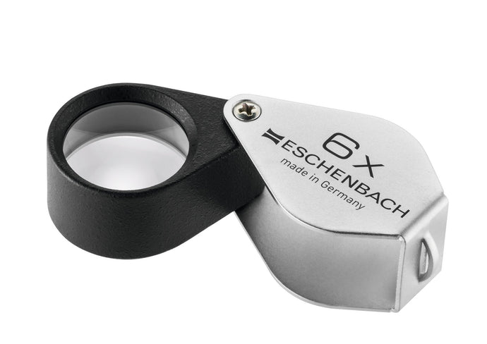 Small circular magnifier encases in black metal, with a silver coloured fold-out case with magnification written on case.