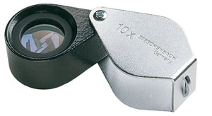 Small circular magnifier encases in black metal, with a silver coloured fold-out case with magnification written on case.