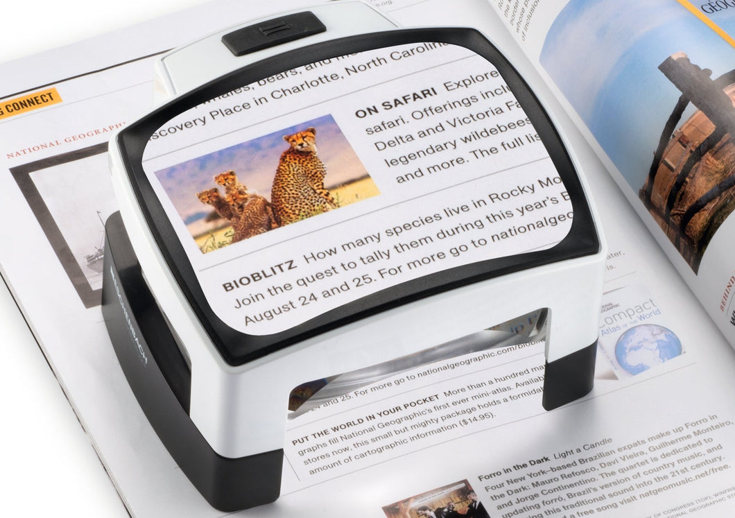 Large, rectangular reading magnifier with sleek design, white and black outlines. Black button for LED light and open base under magnifier
