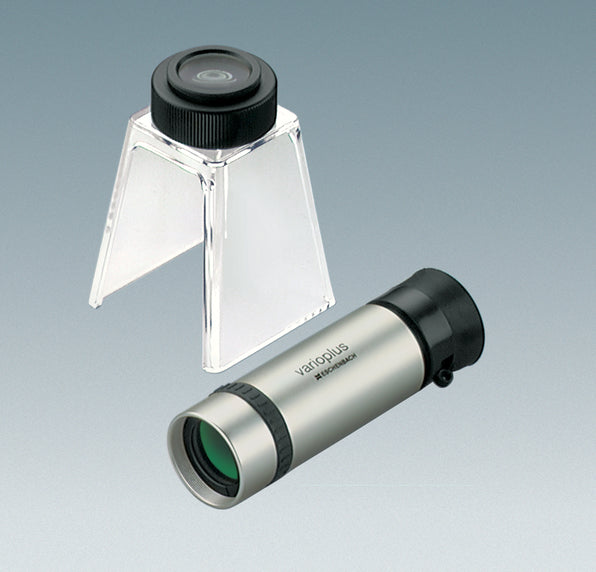 Handheld monocular with silver colour coating and black eyepiece, next to stand with eyepiece for converting monocular to stand magnifier or stand microscope