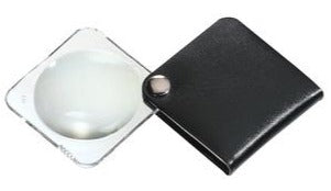 Circular magnifier inside clear square setting, with attached fold-out black case