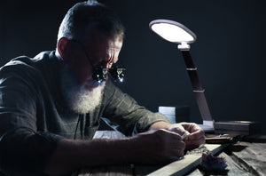 Man using Daylight's Foldi Go to examine a ring in a workshop.