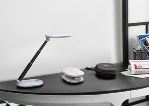 Daylight's Foldi Go, in extended form, compact form and in the case, all on a desk.
