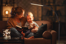 Load image into Gallery viewer, Mother and young boy with a teddy bear, reading a book, sitting on a couch with the Electra lamp next to the couch.
